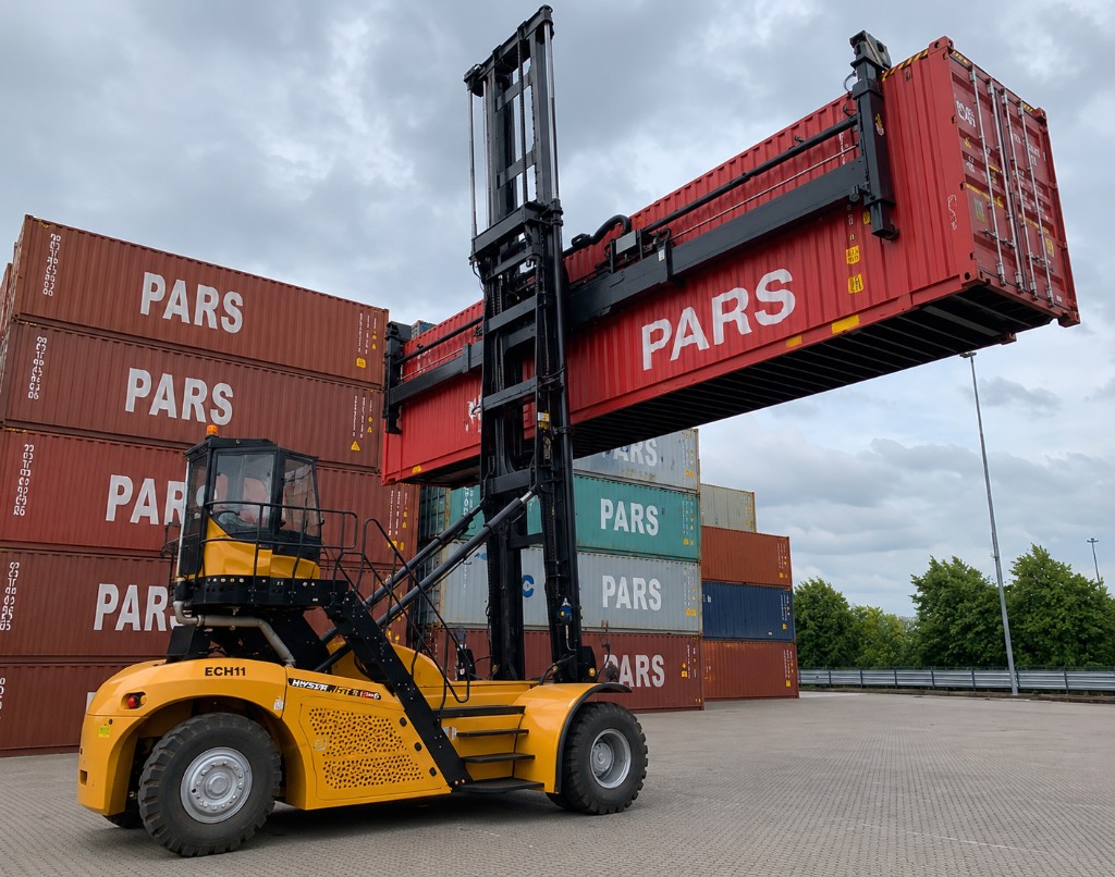 Container handler lifting shipping container in depot yard